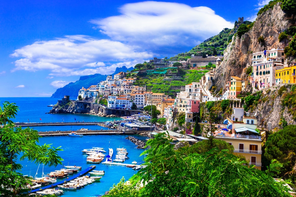 Kvapą gniaužianti Amalfio pakrantė su turkio spalvos įlanka ir spalvingais namais.