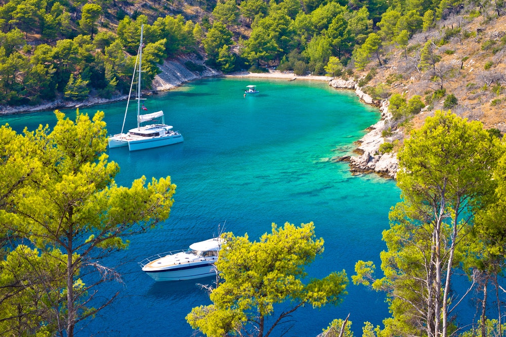 Jachting a plachtění na tajné tyrkysové pláži, ostrov Brač, Dalmácie, Chorvatsko