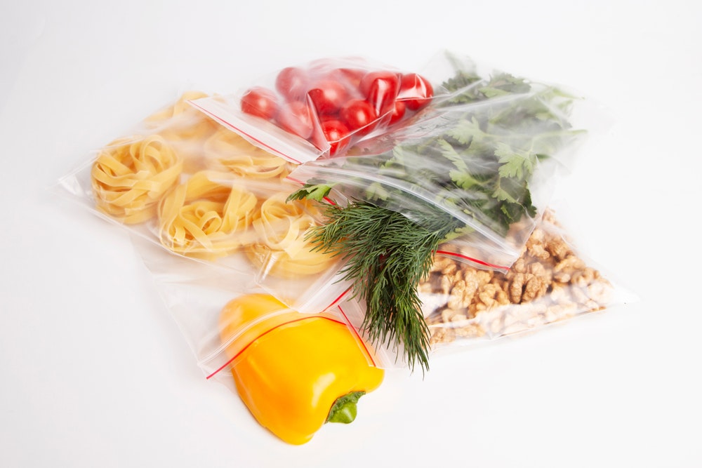 Συσκευασία λαχανικών, λαχανικών και ξηρών καρπών σε κλείσιμο με φερμουάρ σε λευκό φόντο