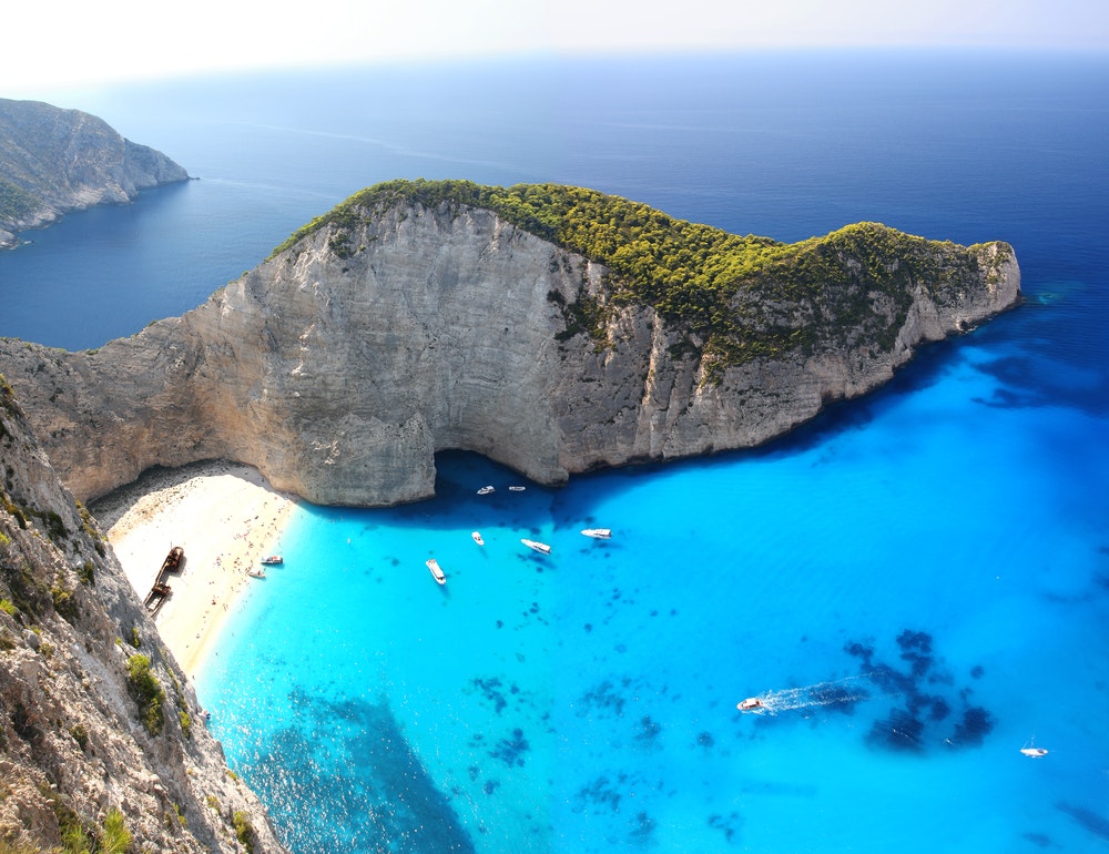 Amazing Navagio beach on the island of Zakynthos, Greece, cliffs, turquoise water, sailboats at anchor. 