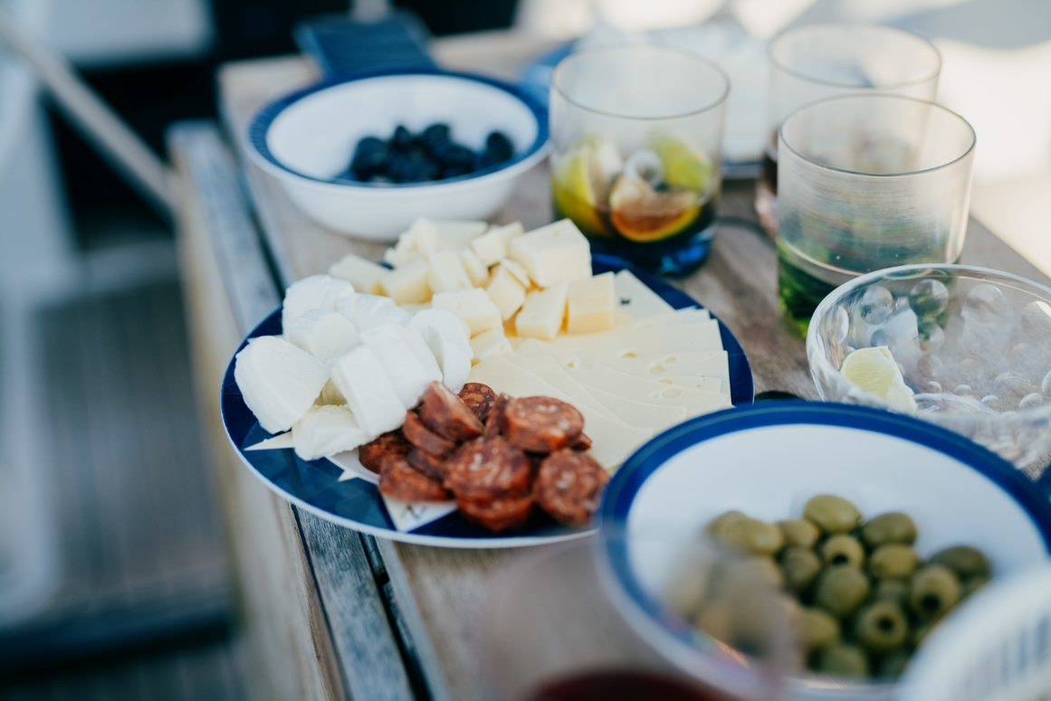 Plates with cheese, sausages, olives.