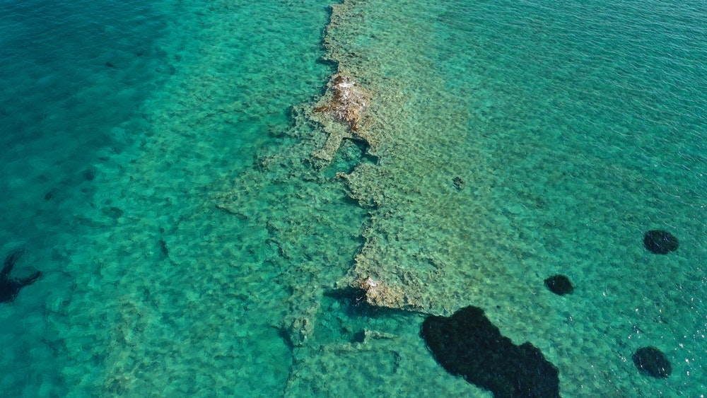 Aerial image of the prehistoric settlement of Pavlopetri, a sunken city and archaeological site just below the surface near the popular beach of Pounta and the island of Elafonisos, Peloponnese, Greece