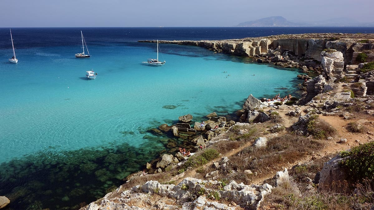 Den himmelblå stranden i Cala Rossa, Sicilia