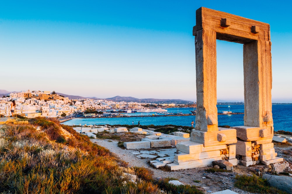Portara, døren på høyden til øya Palatia, den mytiske porten til guden Apollo, i bakgrunnen med bukten og yachter.
