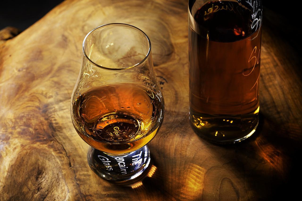 Lahev a sklenička s whiskey nebo rumem
