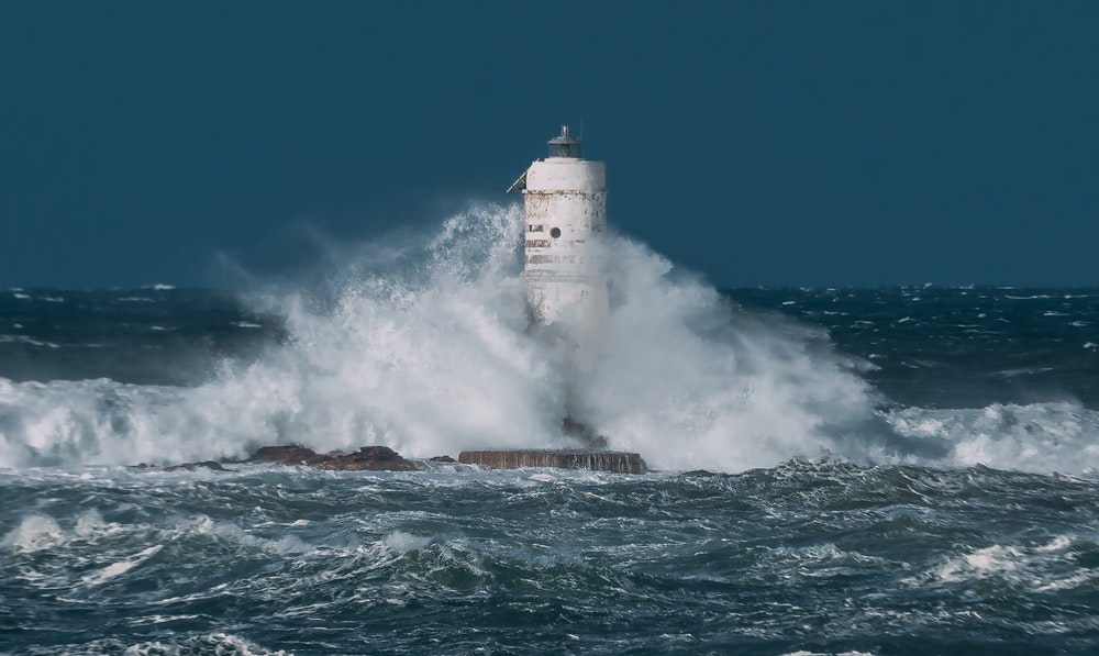 Latarnia morska Mangiabarche z rozbijającymi się o nią wielkimi falami w czasie burzy wiatrowej.