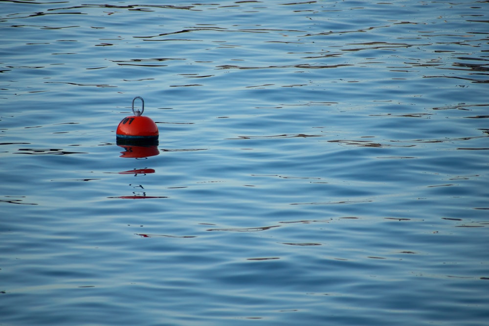 A lone red buoy in the sea.