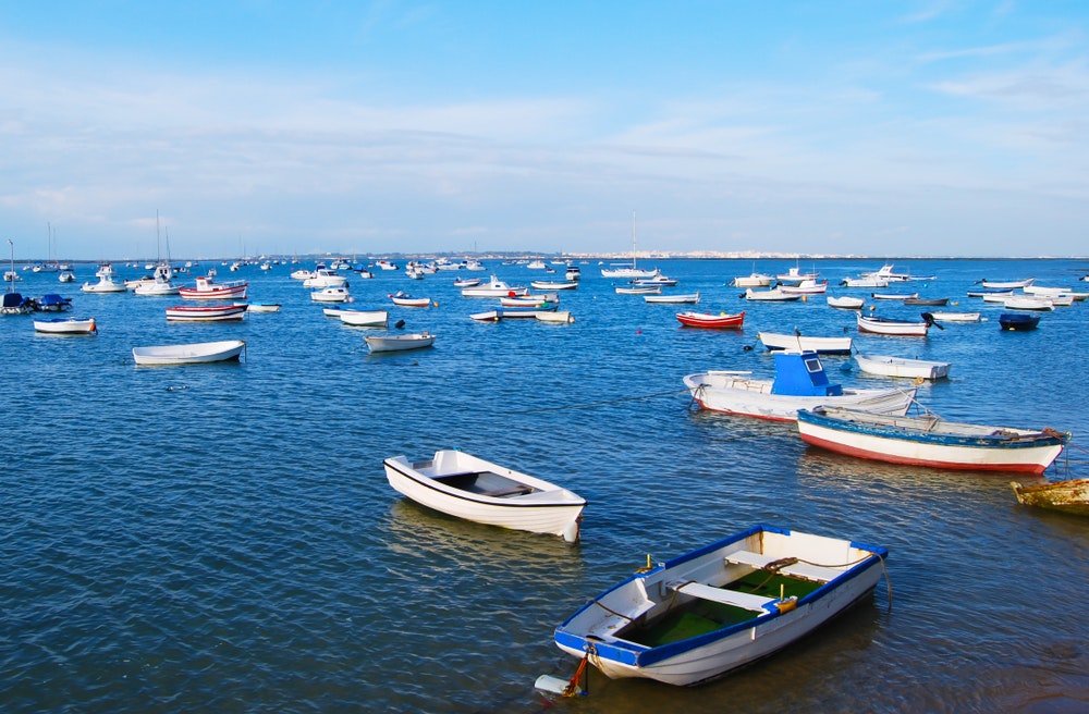 Verschiedene kleine Boote und Schiffe in der Bucht, blauer Himmel, klares Wasser.