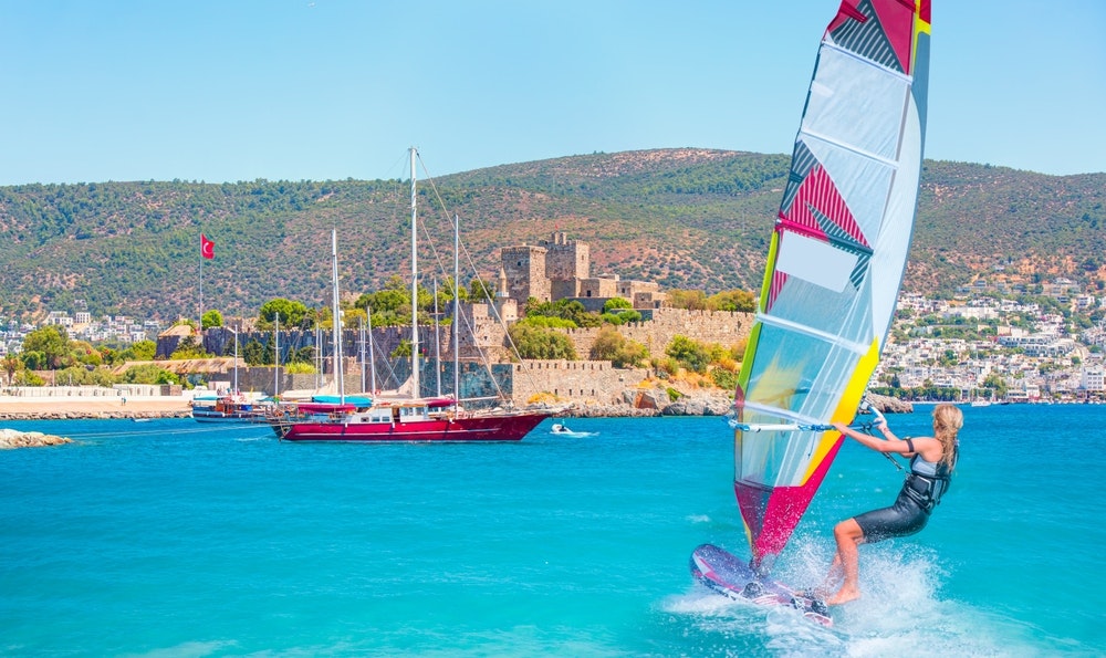 Beautiful blue skies with Windsurfer Surfing Wind On Waves - Saint Peter Castle (Bodrum Castle) and Bodrum Harbour, Turkey