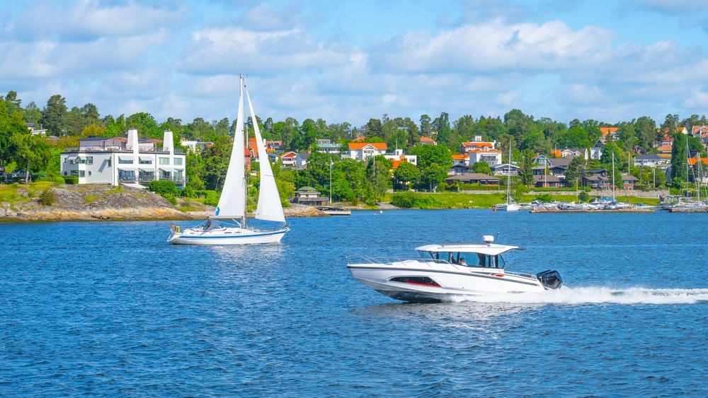 Burlaivis ir motorinė valtis jūroje prie Švedijos krantų plaukia vienas prieš kitą