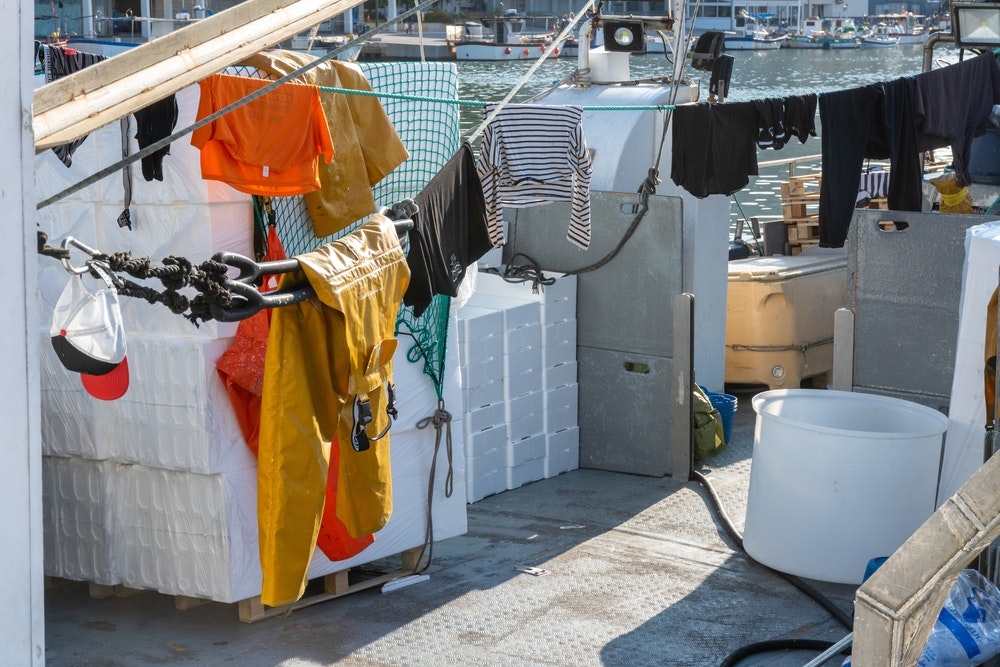 Clothes hanging in the sun and drying on the deck of a fishing boat.