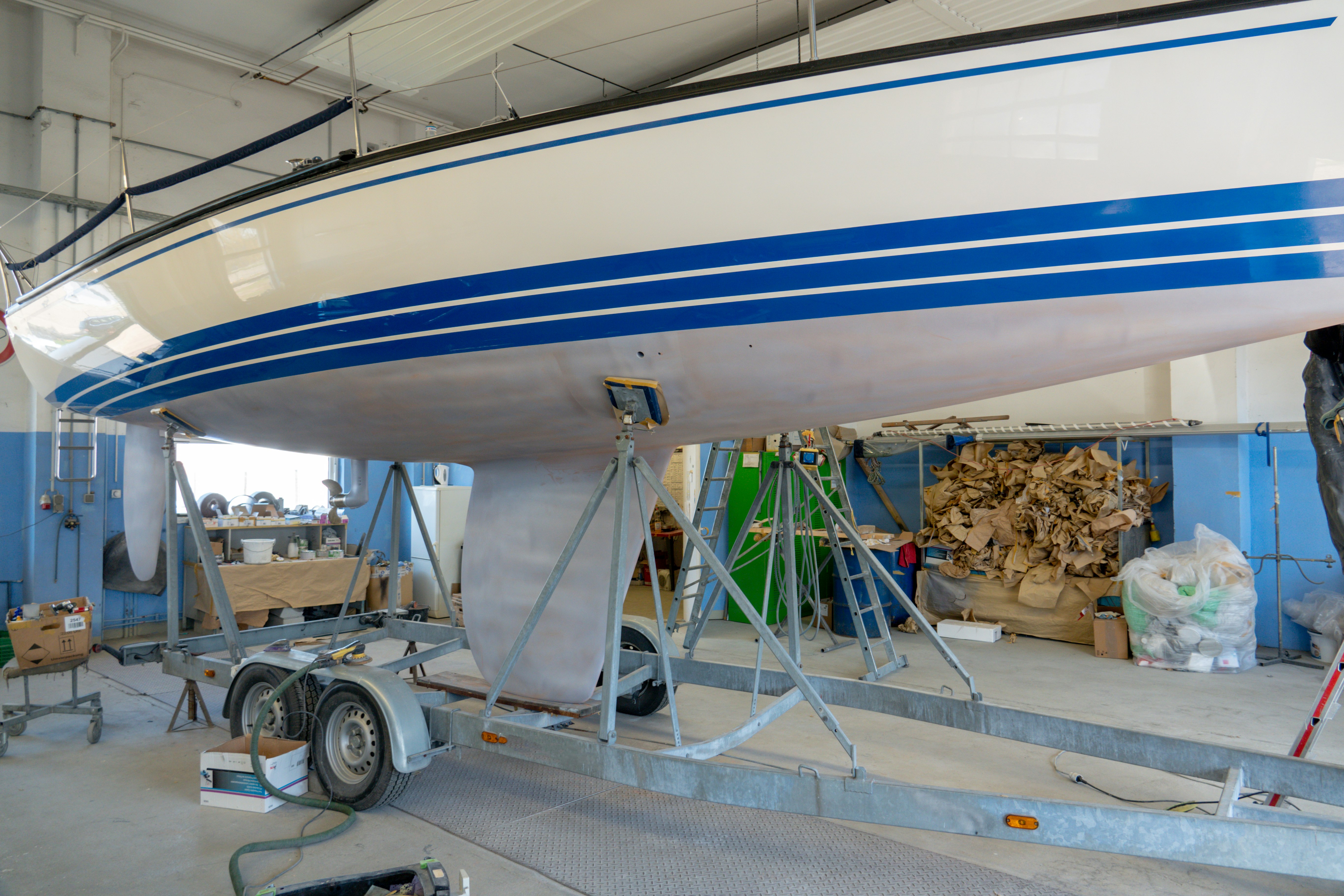 The sailboat sits in the paint shop to be repainted