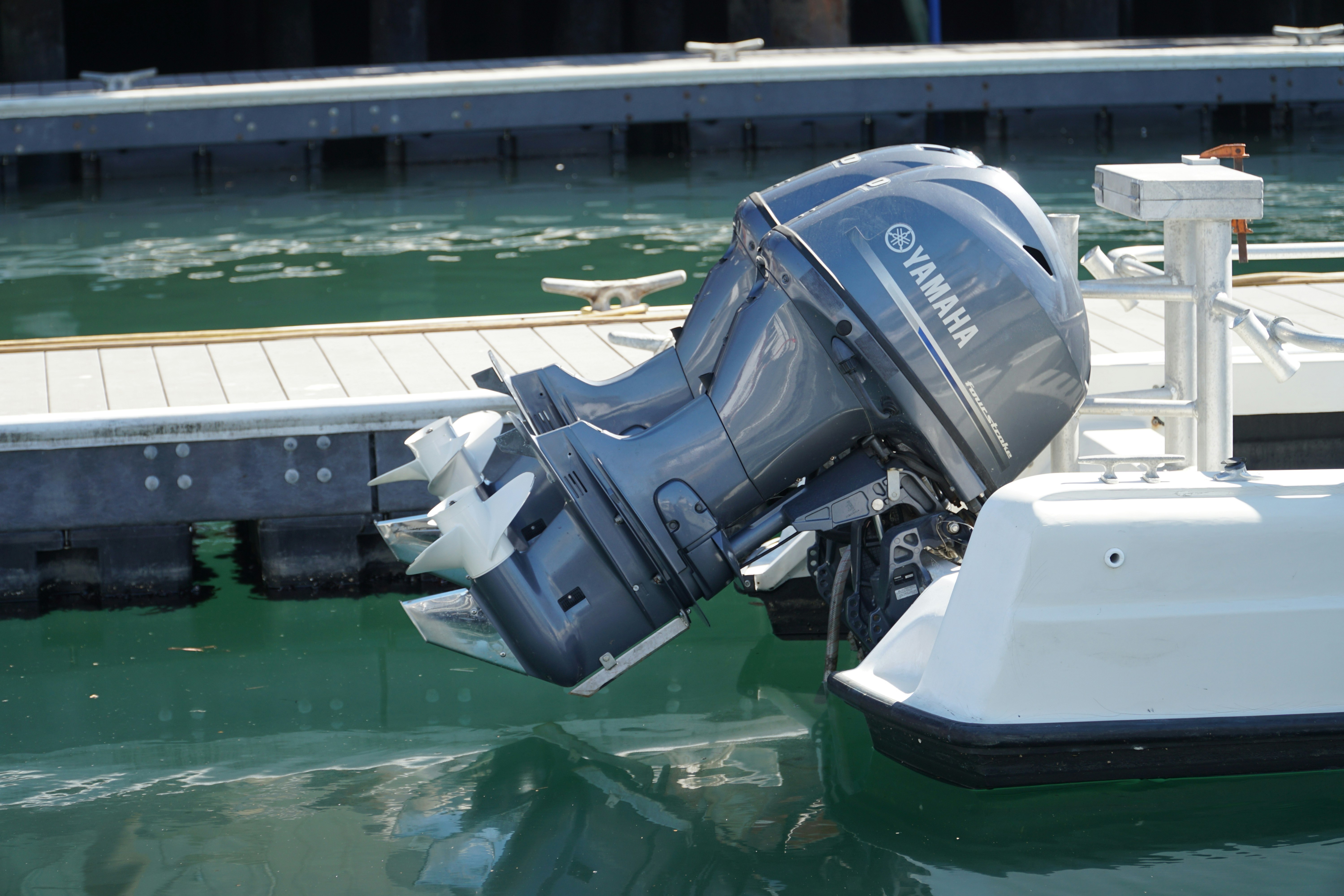 Du "Yamaha" pakabinamieji varikliai ant mažos žvejybos valties galo.