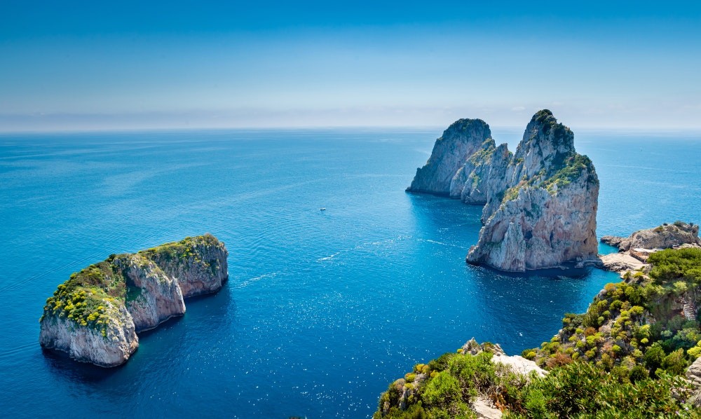 Vaizdas į Faraglioni uolas iš perėjos palei Kaprio pakrantę, Italija.