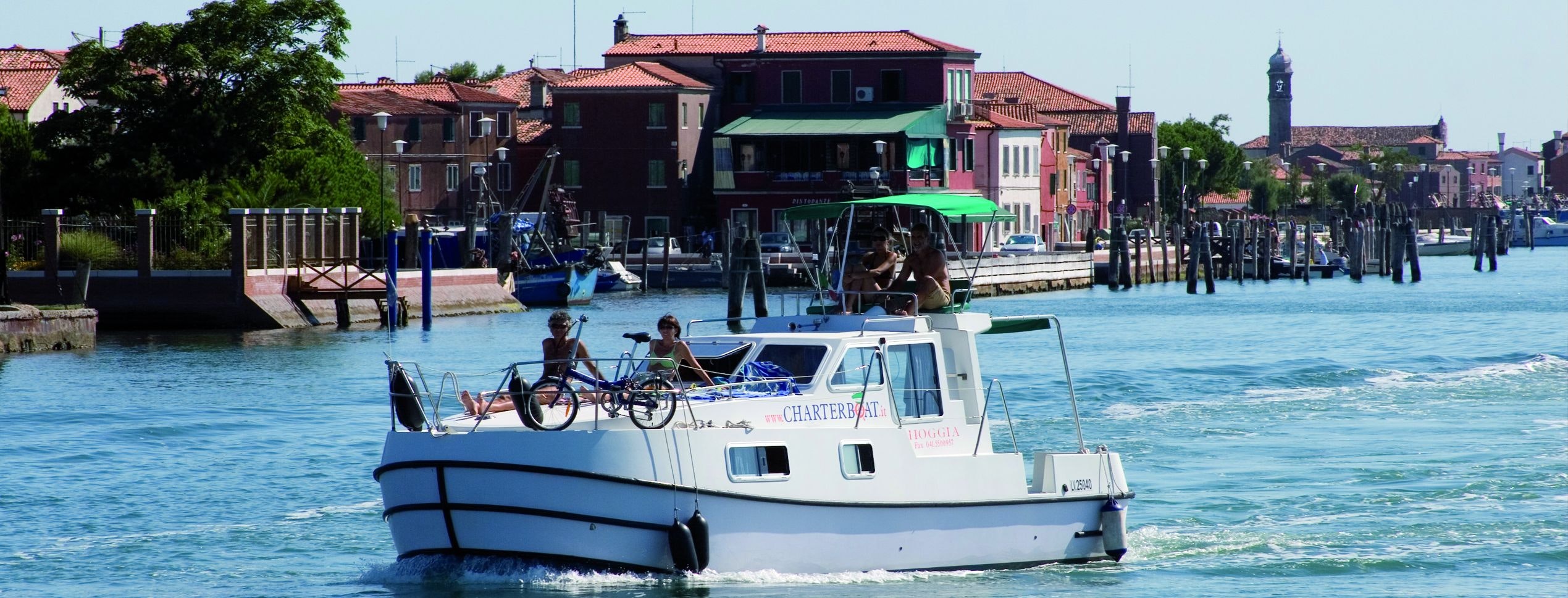 Menschen an Bord eines Hausbootes in der venezianischen Lagune