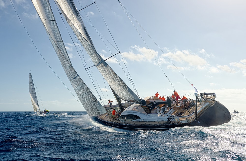 Racing sailboat with crew on board in tilt