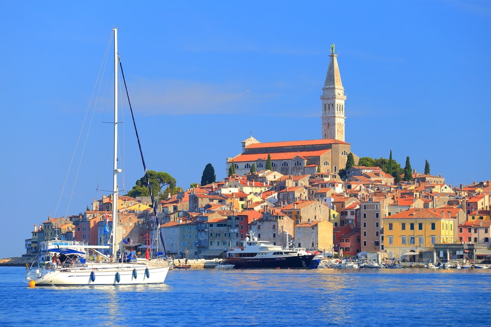 Vysoká plachetnice vstupuje do přístavu starého benátského města Rovinj, Chorvatsko