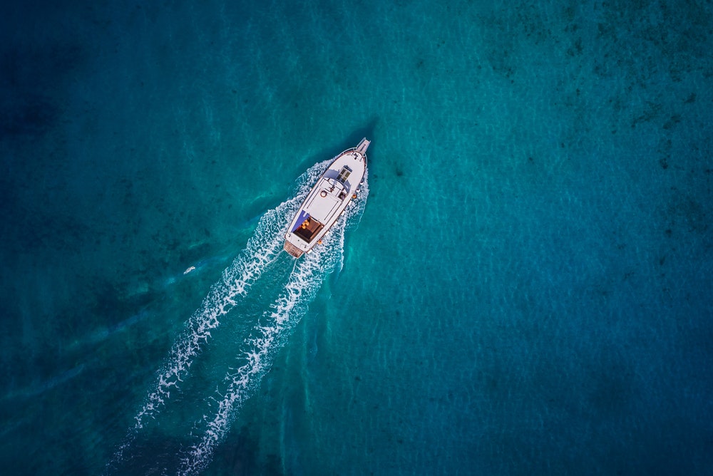 Vintage wooden boat in coral sea, view from the top.