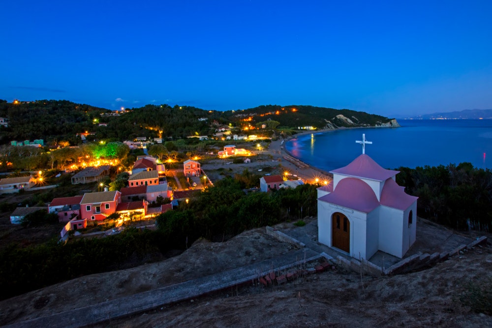 Schöne Aussicht auf die Insel Erikousa mit der orthodoxen Kirche von Erikousa bei Nacht, Griechenland