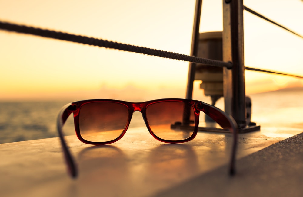 Detail of sunglasses on a boat at sunset.