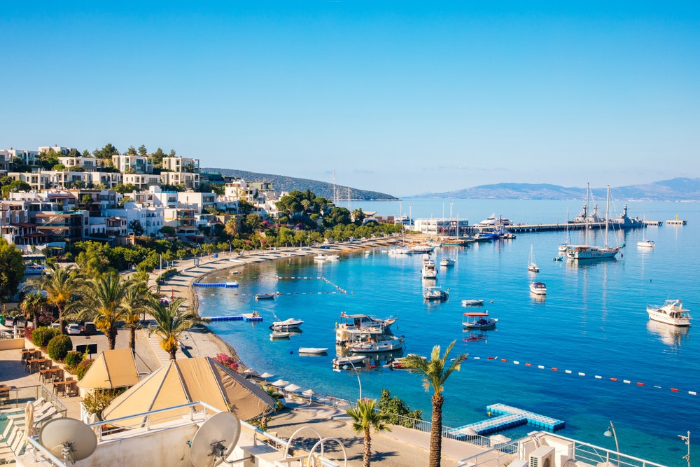View of Bodrum Beach, Aegean Sea, traditional white houses, flowers, marina, sailing boats, yachts in Bodrum Turkey.