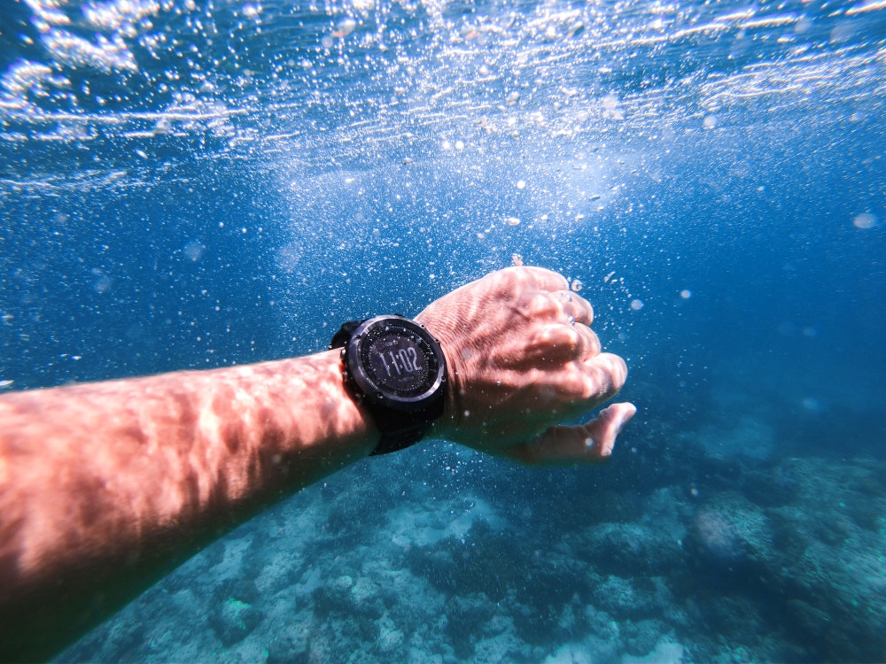 Sportinis chronografas ant rankos po vandeniu. Nardymo aksesuaras su GPS sistema.