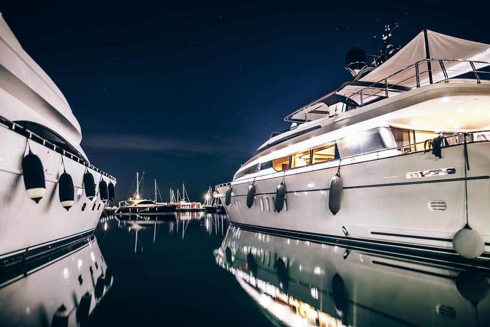 Two luxury yachts anchored in marine at night