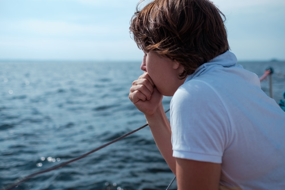 Mladá žena trpí mořskou nemocí během dovolené na lodi