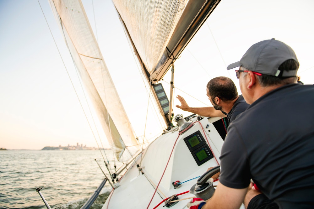 Men on a yacht estimating the distance during a race.