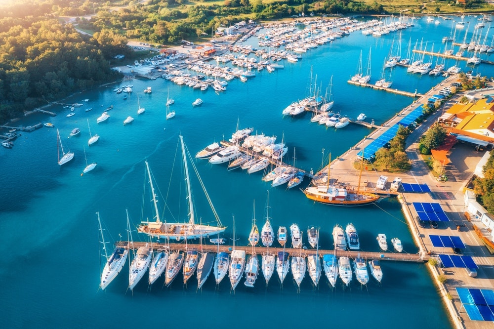 An aerial view of boats and luxury yachts on the docks at sunset in summer in Pula, Croatia. 