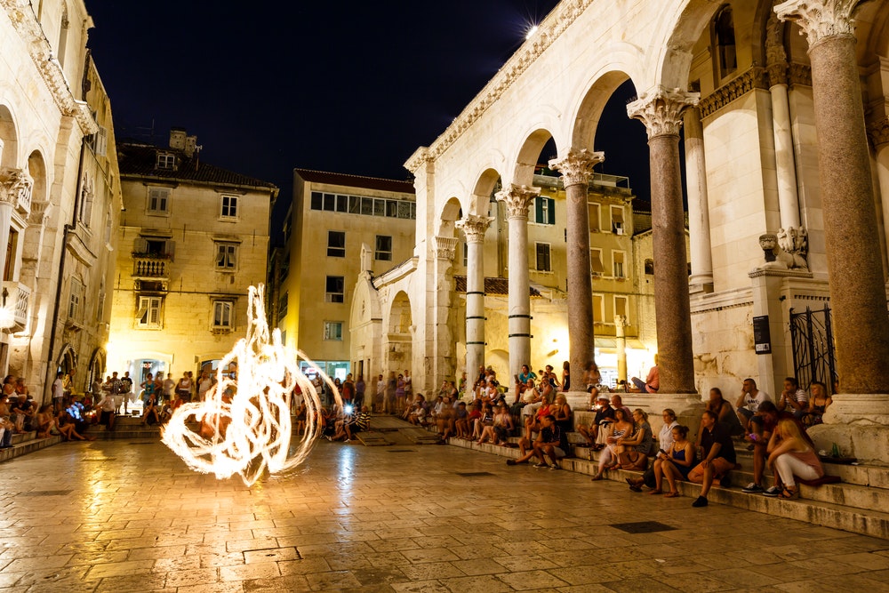 Hırvatistan'ın Split kentindeki Diocletianus Sarayı'nda düzenlenen bir sokak gösterisi sırasında bir ateş hokkabazı performans sergiliyor.