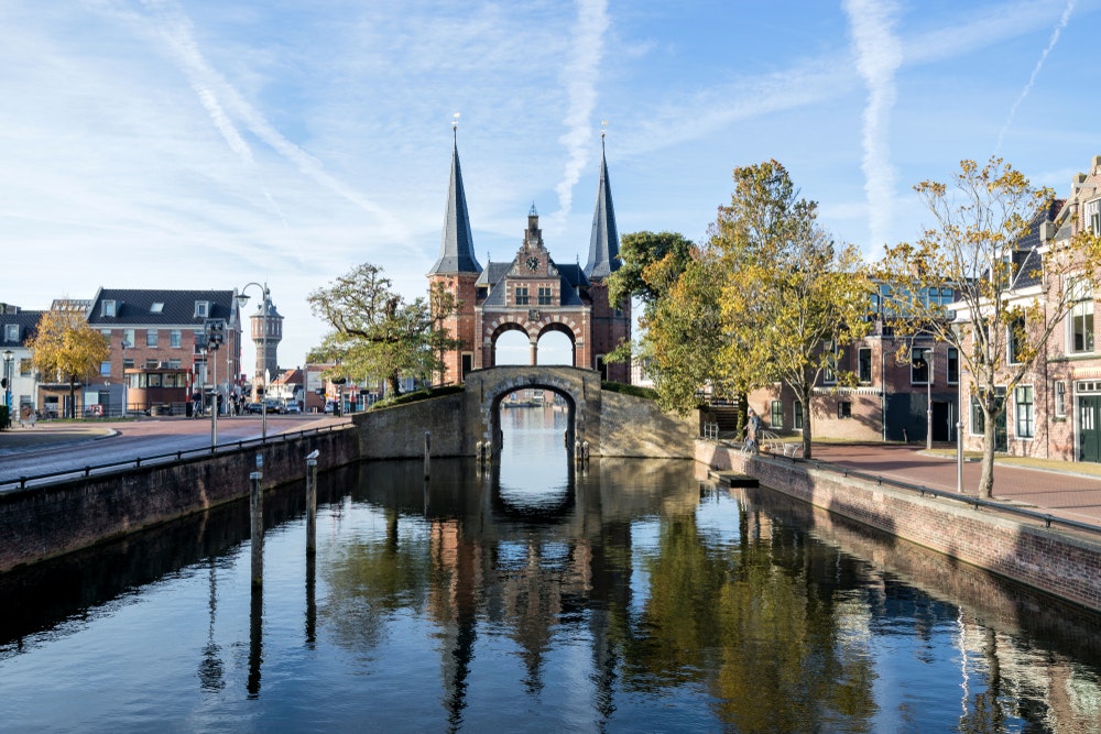 Kamenná historická brána na kanále ve městě Sneek v Nizozemsku.
