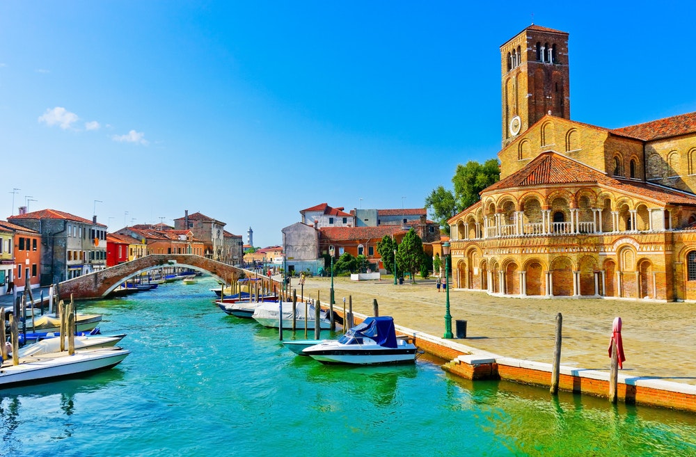 Pohled na barevné benátské domy podél vodního kanálu na Muránských ostrovech v Benátkách.