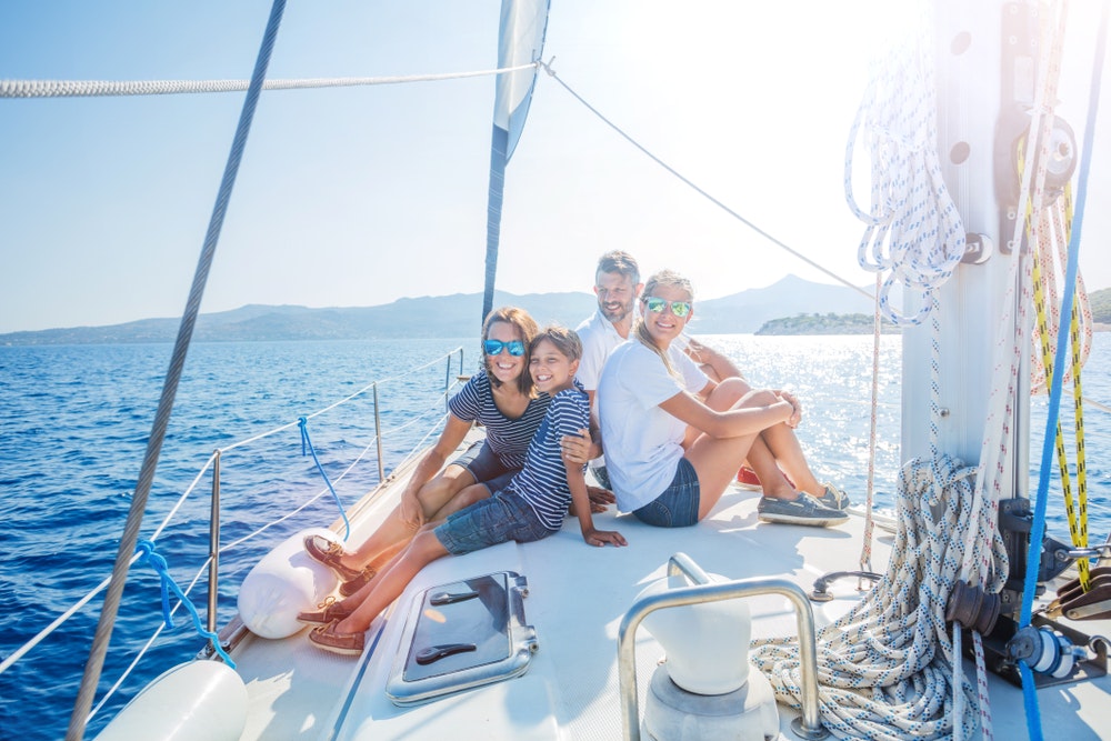 Lykkelig familie med datter og sønn som slapper av på en stor yacht