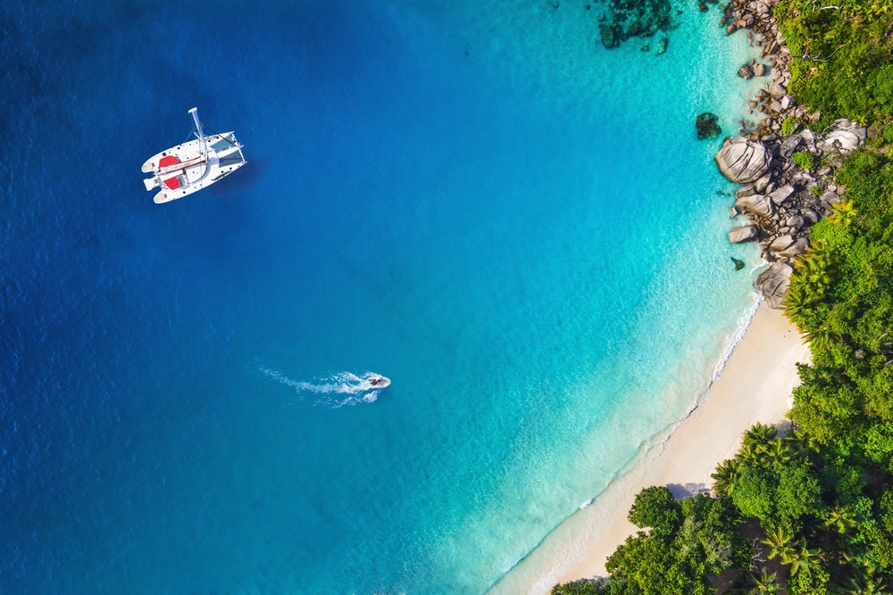 Erstaunlicher Blick auf eine Yacht in einer Bucht mit Strand, Drohnenansicht