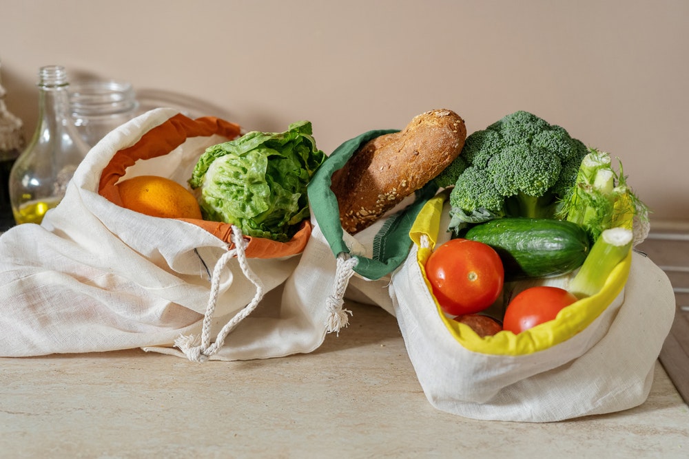 Eco-friendly cotton bags with food on the table.