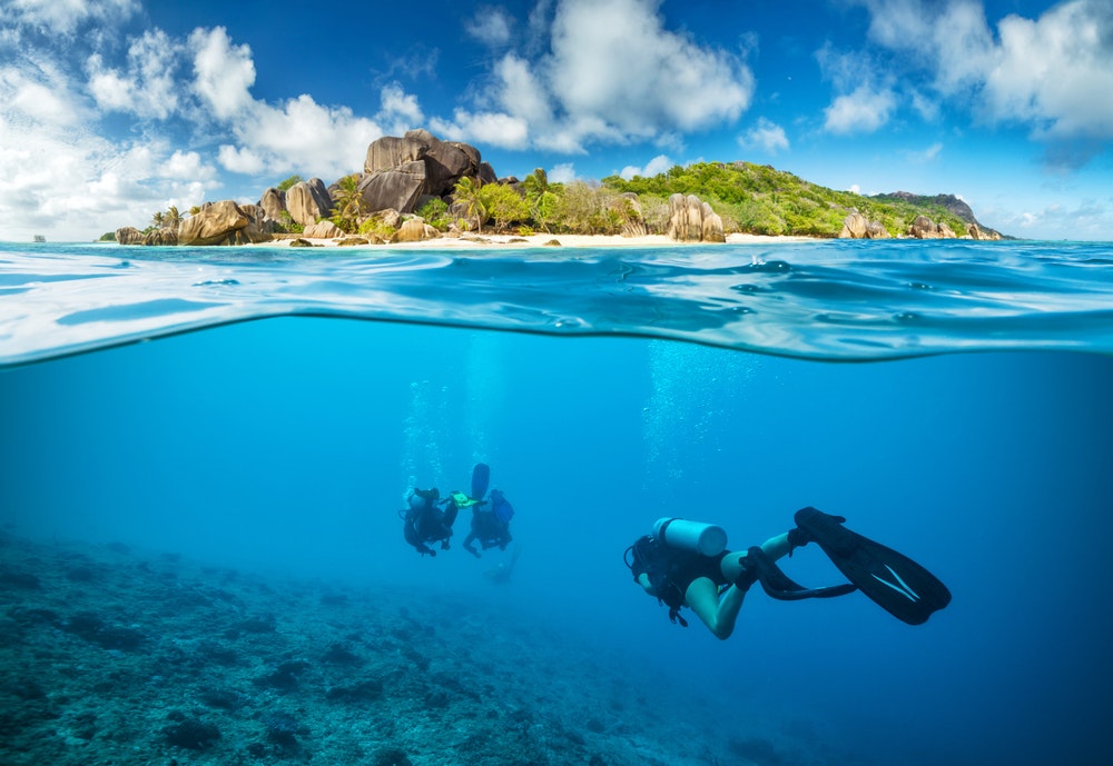Taucher unter Wasser auf den Seychellen entdecken Korallen