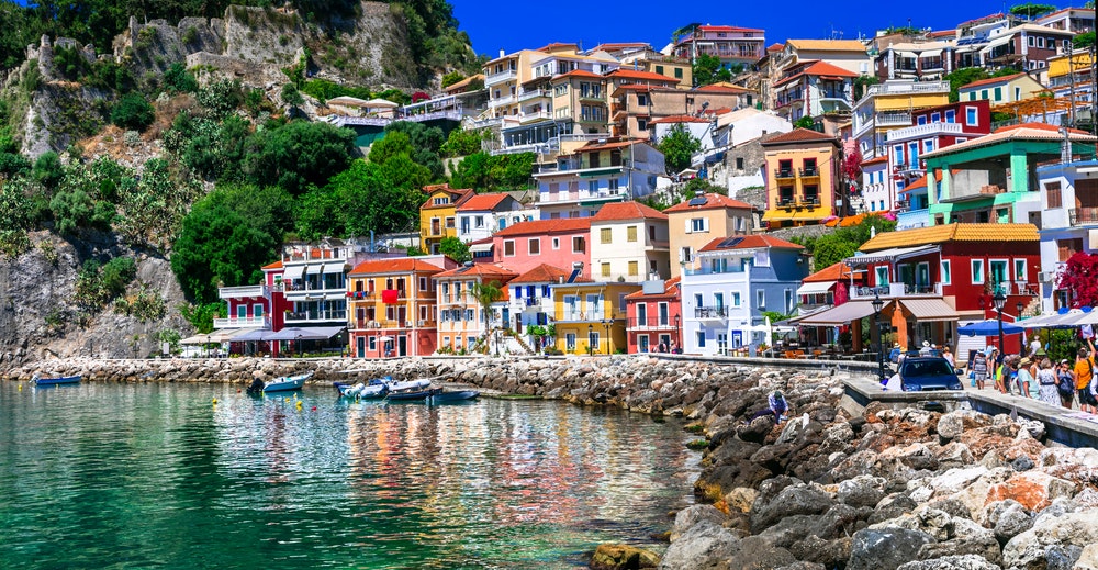 The town of Parga, Greece, historic colourful houses under a cliff.