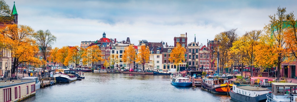 Hollanda, Amsterdam sonbaharda, su kanalının dibinin görünümü, tekneler ve evler