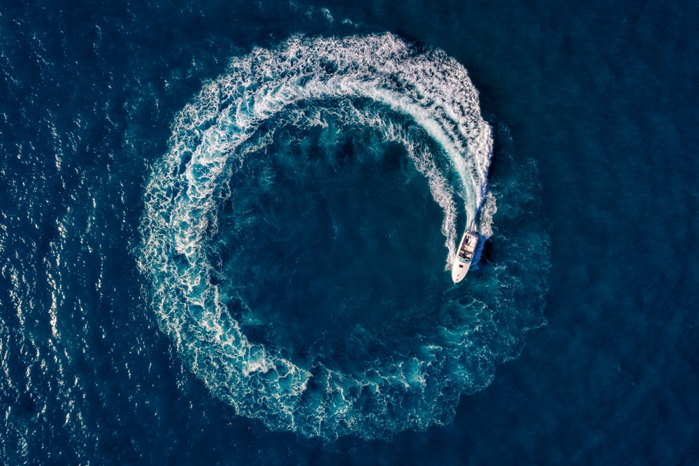 View from the top, photo from the drone, track in a circle behind the motor boat
